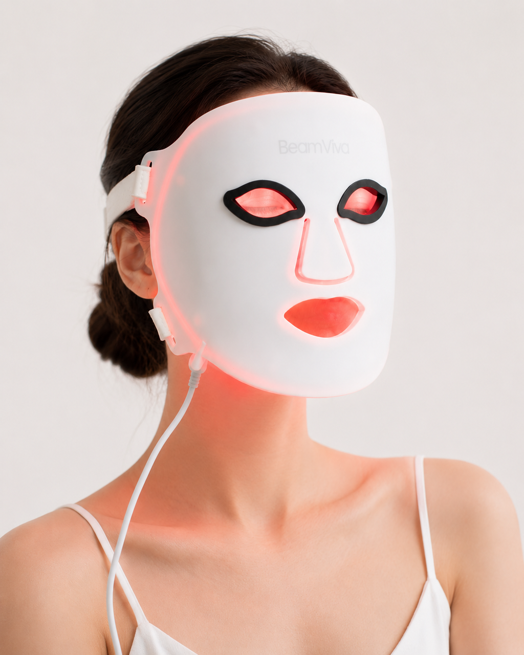 Woman wearing BeamViva LED face mask during red light therapy session